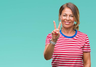 Orta yaş gösterilen ve parmakları ile işaret izole arka plan üzerine İspanyol kadın kıdemli ikincisi ise kendinden emin ve mutlu gülümseyerek.