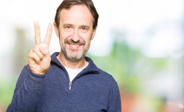 Orta yaş yakışıklı adamın gösterilen ve parmakları ile işaret kazak giydiğini ikincisi ise kendinden emin ve mutlu gülümseyerek.