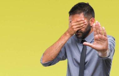 Yetişkin İspanyol iş adam elleriyle gözlerini kapsayan izole arka plan üzerinde ve stop jest ile acı ve korku ifadesi. Utandım ve negatif kavramı.