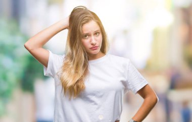 İzole arka plan üzerinde rahat beyaz t-shirt giyen genç güzel sarışın kadın yanıltır ve soru hakkında merak ediyorum. Şüphe, kafasına el ile düşünme ile belirsiz. Dalgın kavramı.