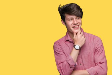 Genç yakışıklı iş adamı emin çapraz kollar ve çeneme kaldırdı el ile gülümseme ile kameraya bakarak izole arka plan üzerinde. Pozitif düşünce.