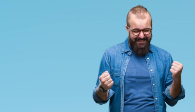 Üzerinde gözlük takan Genç beyaz hipster adam arka plan çok mutlu ve heyecanlı kaldırdı, silah ile kazanan jest yapıyor gülümseyen ve başarı için çığlık izole. Kutlama kavramı.