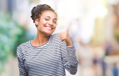 Genç örgülü saç Afro-Amerikan kız mutlu yaşasın el ile jest yapıyor izole arka plan üzerinde kazak giyiyor. Kameraya bakarak başarı gösteren ile ifade onaylama.