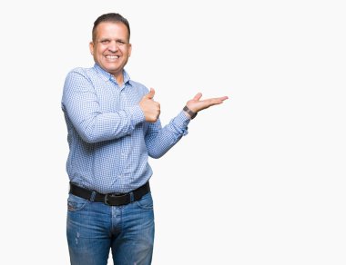 Orta yaş Arap iş adamı üzerinde arka plan gösteren palm el izole ve mutlu ve neşeli gülümseyen thumbs up, ok hareketi ile yapıyor