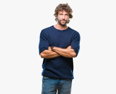 Üzerinde kış kazak giyen yakışıklı İspanyol model adam arka plan ile mutlu yüz gülümseyerek kameraya seyir silah geçti izole. Olumlu bir kişi.