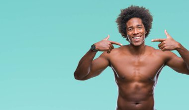 Çıplak vücut kendinden emin gösterilen ve işaret parmakları diş ve ağız ile gülümseyen izole arka plan üzerinde gösterilen Afro Amerikalı gömleksiz adam. Sağlık kavramı.