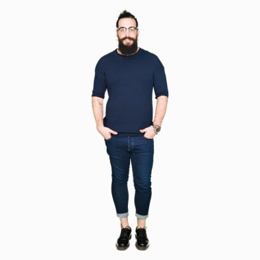 Genç hipster adam uzun saçlı ve gözlüklü mutlu ve güzel bir gülümseme ile yüzünde sakal. Şanslı kişi.