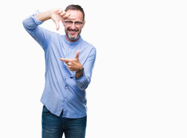 Elle yapma çerçeve ve parmakları ile mutlu yüz gülümseyen izole arka plan üzerinde gözlük takan orta yaş ağarmış komuta sizde. Yaratıcılık ve Fotoğrafçılık kavramı.