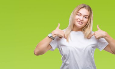 Yüzünde gülümseme ile kendinden emin görünüyorsun, kendini gururlu ve mutlu parmakları ile işaret izole arka plan üzerinde beyaz kadın.