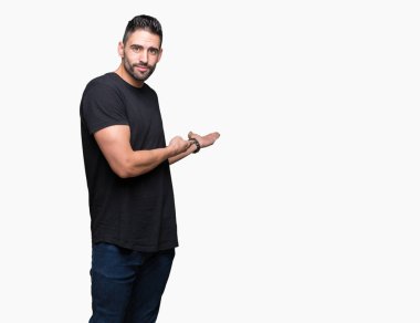 Açık el ile doğal gülümseyen girmek için davet izole arka plan üzerinde genç yakışıklı adam