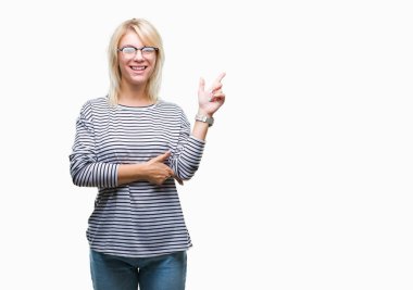 Kameraya bakarak yan el ve parmak ile işaret yüzünde kocaman bir gülümseme ile izole arka plan üzerinde gözlük takan genç güzel sarışın kadın.