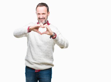 Kalp simgesi ve elleriyle şekil gösterilen aşık gülümseyen izole arka plan üzerinde kış kazak giyen orta yaş ağarmış komuta sizde. Romantik kavramı.