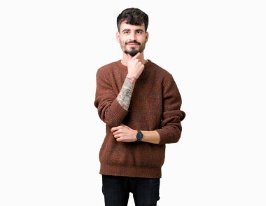 Emin çapraz kollar ve çeneme kaldırdı el ile gülümseme ile kameraya bakarak izole arka plan üzerinde kış kazak giyen genç yakışıklı adam. Pozitif düşünce.