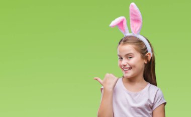 Paskalya bunny kulaklar seyir ve başparmak yanında yukarıyı mutlu yüz ile gülümseyen izole arka plan üzerinde giyen genç güzel kız.