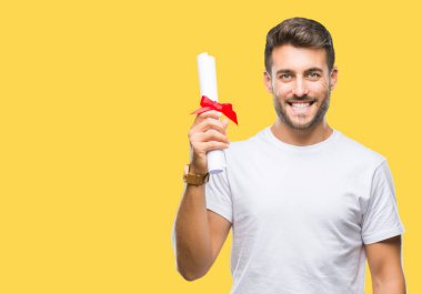 Yakışıklı delikanlı derecesi izole arka plan üzerinde duran ve diş gösterilen kendine güvenen bir gülümsemeyle gülümseyerek mutlu bir yüz ile tutarak