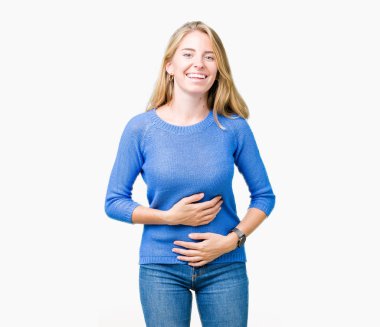 Mavi kazak izole üzerinde giyen güzel genç kadın arka plan gülen ve komik deli şaka çünkü yüksek sesle zor gülüyor. Mutlu ifade.