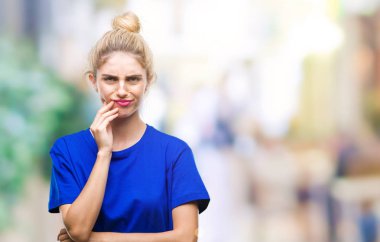 Diş ağrısı veya dişlerde dişlerle ilgili hastalık nedeniyle ağız acı ifadesi ile el ile dokunmak izole arka plan üzerinde mavi t-shirt giyen genç güzel sarışın ve mavi gözlü kadın. Diş hekimi kavramı.