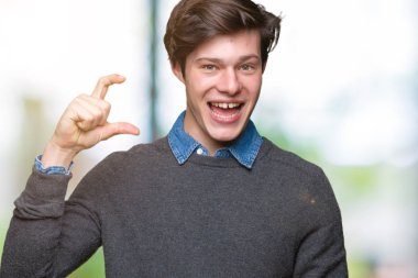 Yakışıklı zarif genç gülümseyen izole arka plan ve süre seyir ve kamera boyutu işaret parmaklarıyla yapıyor el ile kendinden emin eller üzerinde. Ölçü kavramı.