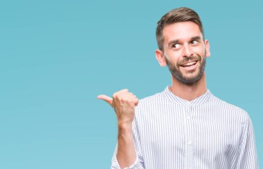 Yakışıklı delikanlı arıyor ve başparmak yanında yukarıyı mutlu yüz ile gülümseyen izole arka plan üzerinde.