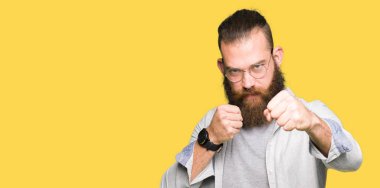 Savaşmak için saldırgan ve kızgın saldırı, tehdit ve şiddet kum yumruk giyen genç sarışın adam gözlük