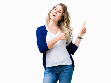 Gülümseyen ve iki elleri ve parmakları ile tarafına işaret kamera bakarak izole arka plan üzerinde sarışın güzel genç kadın.