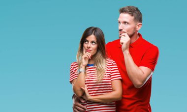 Genç çift çene düşünme hakkında soru, dalgın ifade üzerine el ile izole arka plan üzerinde aşık. Düşünceli yüzüyle gülümsüyor. Şüphe kavramı.