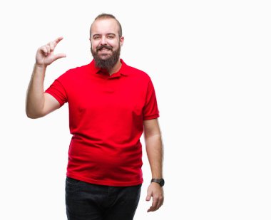 İzole arka plan gülümseyen ve boyutu işaret parmaklı ararken ve kamera işi el ile kendinden emin eller üzerinde kırmızı gömlek giyen genç beyaz hipster adam. Ölçü kavramı.