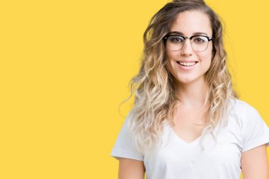 Yüzünde mutlu ve güzel bir gülümseme ile izole arka plan üzerinde gözlük güzel sarışın genç kadın. Şanslı kişi.