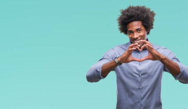 Kalp simgesi ve elleriyle şekil gösterilen aşık gülümseyen izole arka plan üzerinde Afro Amerikalı adam. Romantik kavramı.