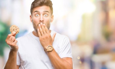 Hata, korku, sessizlik içinde gizli kavramı korkmuş ifade için utanç ile yakışıklı delikanlı izole arka kapak ağız el ile üzerinden çikolata çerez yemek şok