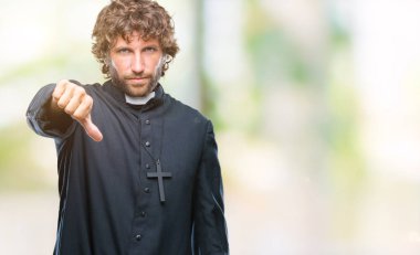 Yakışıklı İspanyol Katolik rahip adam mutsuz ve kızgın ret gösterilen ve başparmak aşağı hareketi ile negatif seyir izole arka plan üzerinde. Kötü ifade.