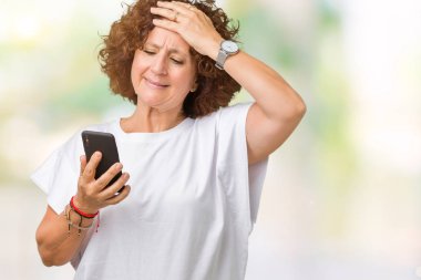 Kullanan orta ager üst düzey kadın, mesaj ile smartphone kafa, utanç ve sürpriz ile şok üzerinde el ile vurguladı izole arka plan üzerinde yüz, öfkeli ve sinirli. Korku ve hata için üzgün.