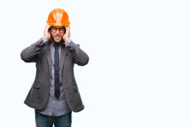 Çünkü çaresiz ve stresli baş ağrısı acı izole arka plan üzerinde güvenlik kask giymiş uzun saçlı Genç yakışıklı architec adam ağrı ve migren. Ellerini kafasına.