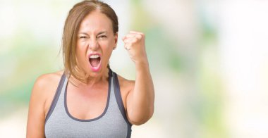 Güzel orta yaş kadın spor kıyafetlerle üzerinde arka plan kızgın izole ve kızgın yetiştirme hayal kırıklığı ve öfke ile bağırarak süre öfkeli yumruk. Öfke ve agresif kavramı.