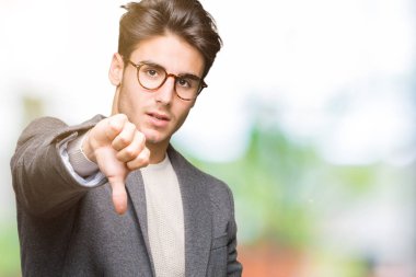 Mutsuz ve kızgın ret gösterilen ve başparmak aşağı hareketi ile negatif seyir izole arka plan üzerinde gözlük takan genç iş adamı. Kötü ifade.