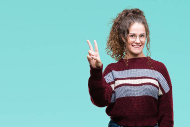 Güzel esmer kıvırcık saçlı Genç kız üzerinde gözlük takan gösterilen arka plan izole ve parmakları ile işaret kendinden emin ve mutlu gülümseyerek ise ikinci.