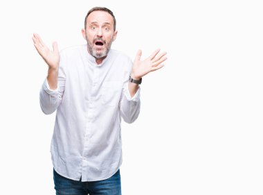 Orta yaş izole arka plan clueless ve şaşkın bir ifadeyle kollar ve eller kaldırdı üzerinde ağarmış komuta sizde. Şüphe kavramı.