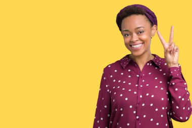 Gösterilen ve parmakları ile işaret izole arka plan üzerinde başörtüsü giyen güzel genç Afro-Amerikan kadın ikincisi ise kendinden emin ve mutlu gülümseyerek.