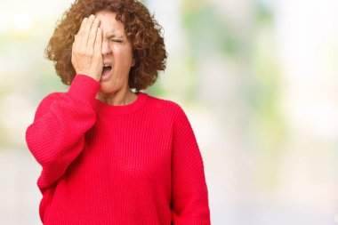 Güzel orta ager kadın kıdemli kırmızı kış kazak üzerine yarım yüz, göz ve ağız el ile kapsayan Yawning yorgun arka plan izole. Acı yüzü acıyor.