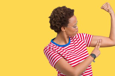 Güzel genç Afro-Amerikan kadın kol kas, kendinden emin ve güç gurur gösteren izole arka plan güçlü kişi üzerinde gözlük