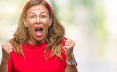 İzole arka plan kutlama üzerinde orta yaş İspanyol kadın kıdemli şaşırttı ve başarı için kaldırdı kollarını açarak hayret ve gözleri açık. Kazanan kavramı.