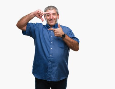 Elle yapma çerçeve ve parmakları ile mutlu yüz gülümseyen izole arka plan üzerinde yakışıklı komuta sizde. Yaratıcılık ve Fotoğrafçılık kavramı.