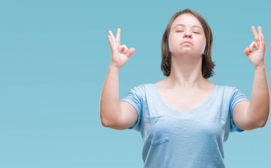 Down sendromlu izole arka plan üzerinde Genç Yetişkin kadın rahatla ve gülümseyen gözlerle kapalı parmak jestle meditasyon yapıyor. Yoga kavramı.