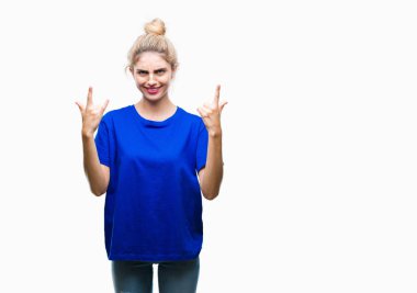Deli ifade rock simge elle yapıyor ile bağırarak izole arka plan üzerinde mavi t-shirt giyen genç güzel sarışın ve mavi gözlü kadın. Müzik yıldızı. Ağır kavramı.