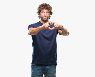 Yakışıklı İspanyol modeli adam aşık kalp simgesi ve elleriyle şekil gösteren gülümseyen izole arka plan üzerinde. Romantik kavramı.