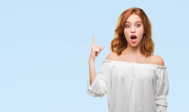 Genç güzel kadın başarılı fikirle parmağı yukarıyı izole arka plan yüzünden. Çıktıktan ve mutlu. Bir numara.