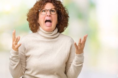 Boğazlı kazak ve gözlük izole arka plan çılgın ve kızgın bağırarak ve agresif ifade ve silah kaldırdı bağırmaya üzerinde giyen güzel orta ager üst düzey kadın. Hayal kırıklığı kavramı.