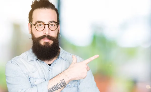 Joven Hipster Hombre Con Pelo Largo Barba Con Gafas Señalando —  Fotos de Stock