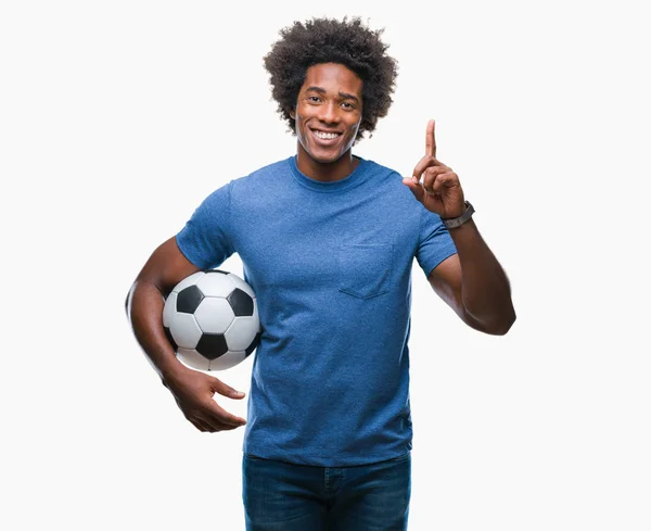 アフロ アメリカ人持株サッカー ボールのアイデアに驚いて孤立の背景の上や幸せそうな顔 ナンバーワンと人差し指の質問 — ストック写真