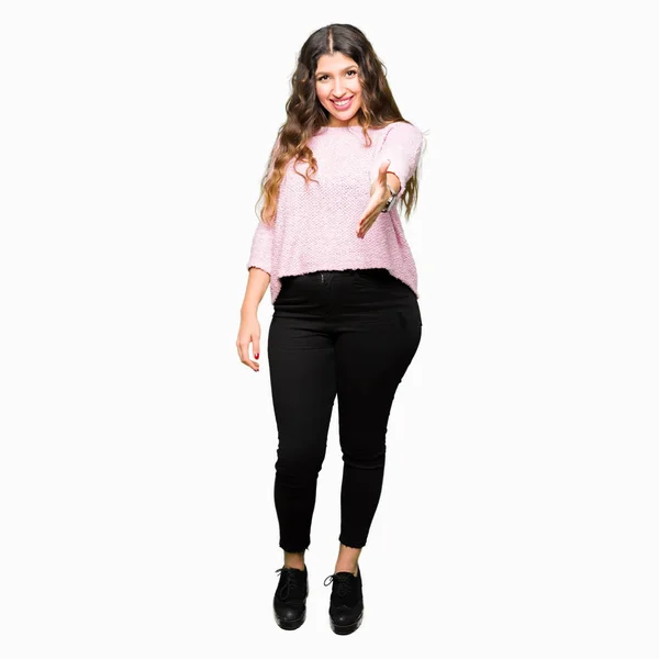 若い美しい女性の笑顔挨拶と歓迎フレンドリーな提供ハンドシェイク ピンクのセーターを着ています ビジネスの成功 — ストック写真